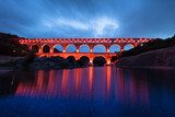 Ponte antico illuminato con riflessi sull'acqua