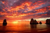 Tramonto infuocato sul mare roccioso