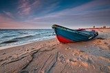 Tramonto sul litorale con barca in legno